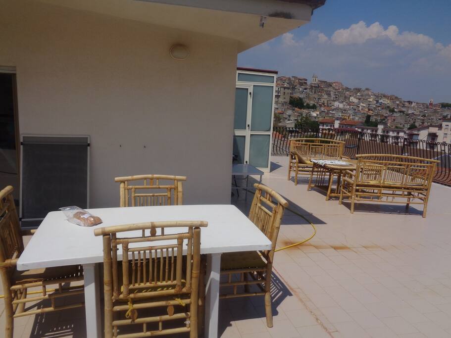 terrasse équipée de table, chaises, salon modulable et vue dégagée imprenable sur le village ancien de casteltermini