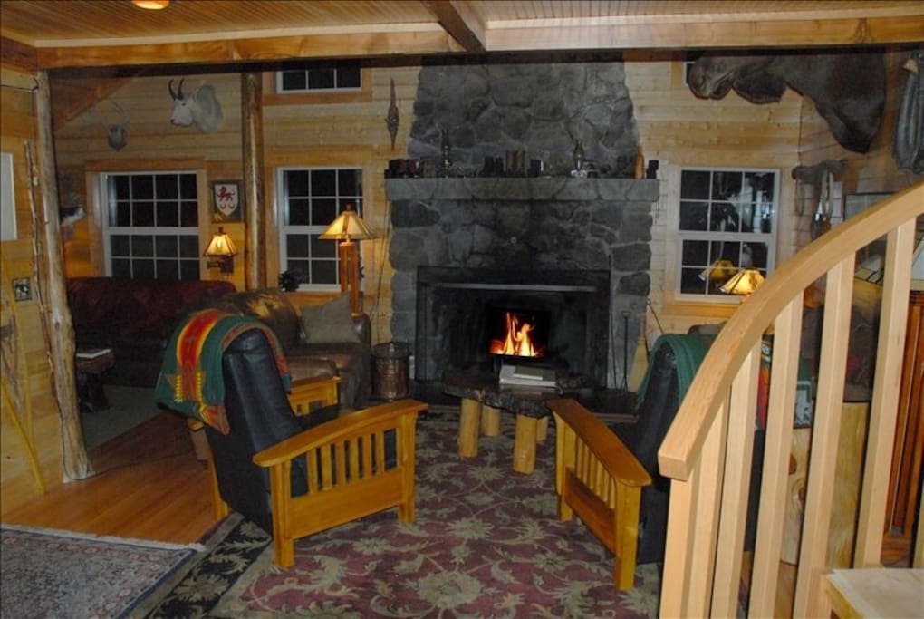 Living room with plenty of couches for lounging and a large fireplace