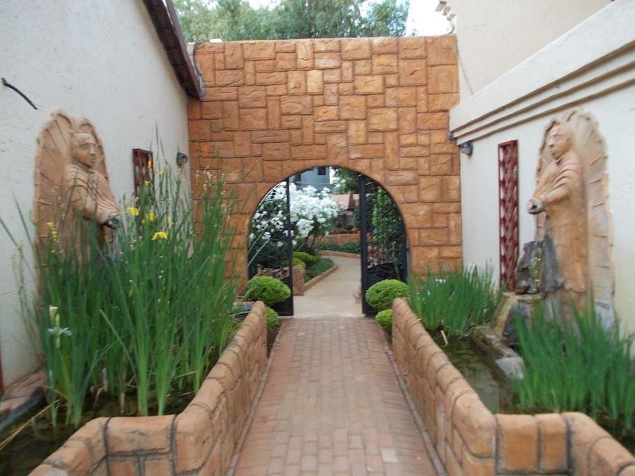 Entrance from the parking to some of the rooms, bar, swimming pool, dining area, fish pond and a beautiful garden