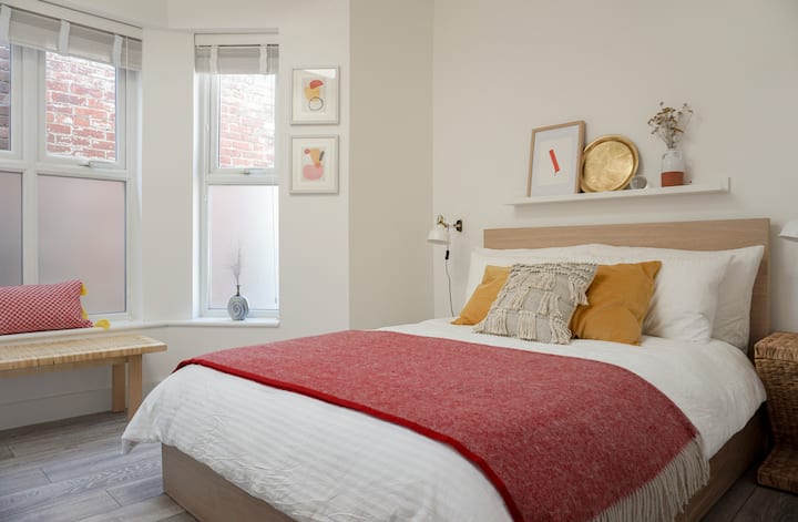 ห้องนอน - ตกแต่งด้วยสีและพื้นผิวที่อบอุ่นและน่าอยู่มีเตียงคู่ในสหราชอาณาจักร (135 ซม x 190 ซม.) พร้อมผ้าปูที่นอนที่กรอบสะอาดและหมอนและเบาะนุ่มฟูตกแต่งด้วยลายพิมพ์งานศิลปะต้นฉบับและเซรามิคในสตูดิโอ