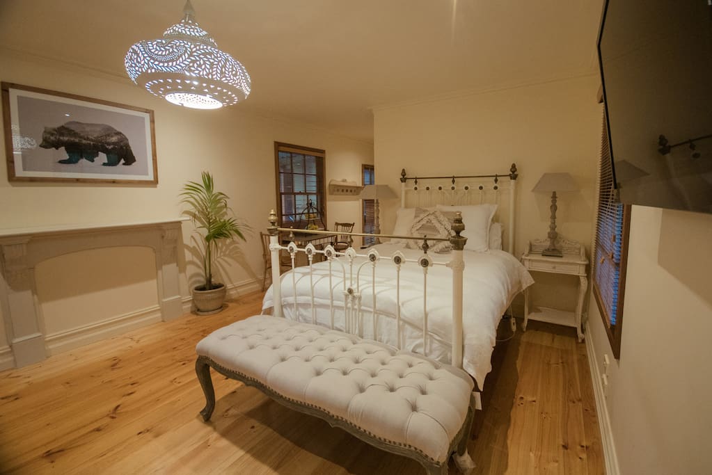 Large spacious Master bedroom with queen bed . A TV on the wall , to lie back and enjoy the evening or wake up and watch the news with the click of the remote