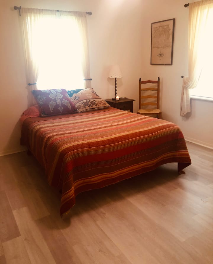 Cama queen en la habitación de invitados en la casa principal.
