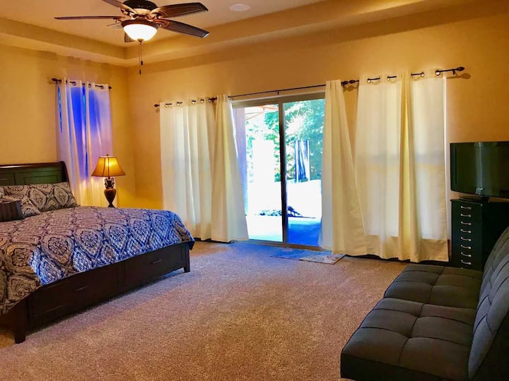 Habitación grande en la planta baja con cama tamaño king y puerta privada al patio trasero. El sofá se pliega para dormir más. También hay baño privado con ducha a ras de suelo.