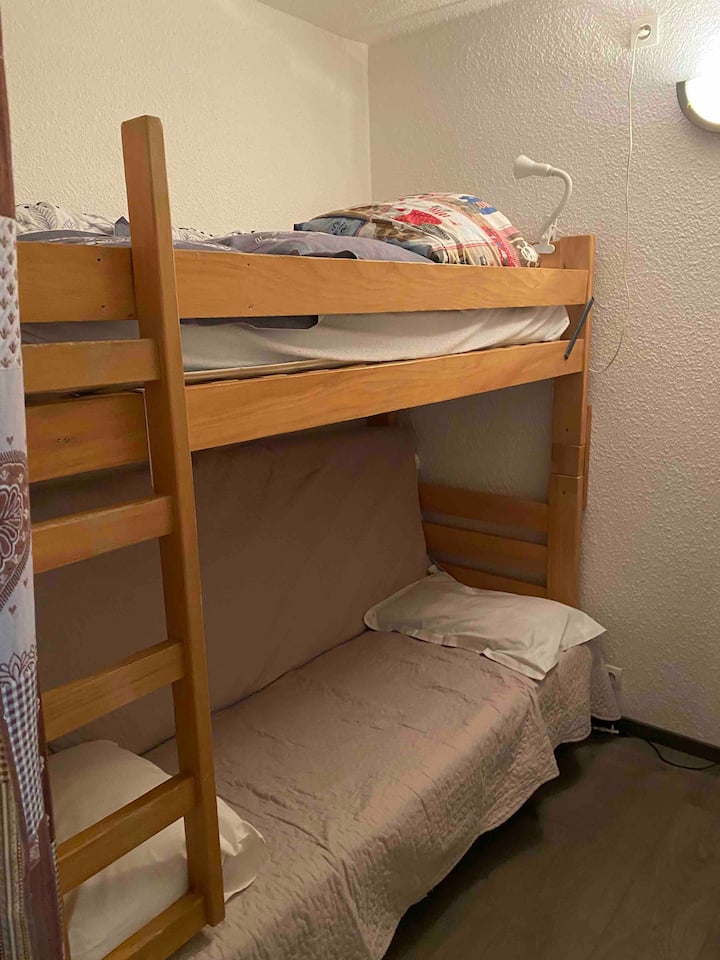 חדר שינה עם ספה נפתחת ומיטת קומתיים.