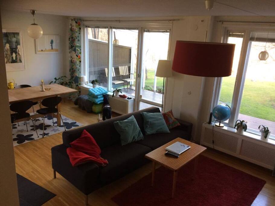 Vardagsrum med soffa, tv och öppen spis. Fönster mot gavel och baksida.