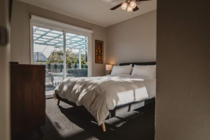 ห้องนอนผู้เข้าพัก #2 พร้อมเตียงควีนไซส์และประตูบานเลื่อนไปยังบริเวณสระว่ายน้ำ