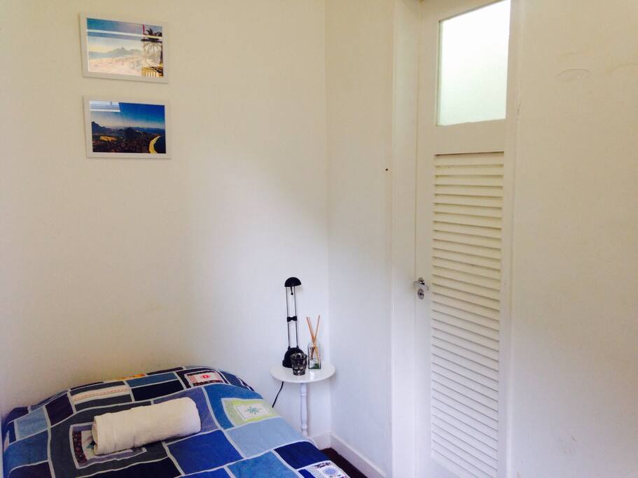 Quarto com cama de solteiro e banheiro privativo