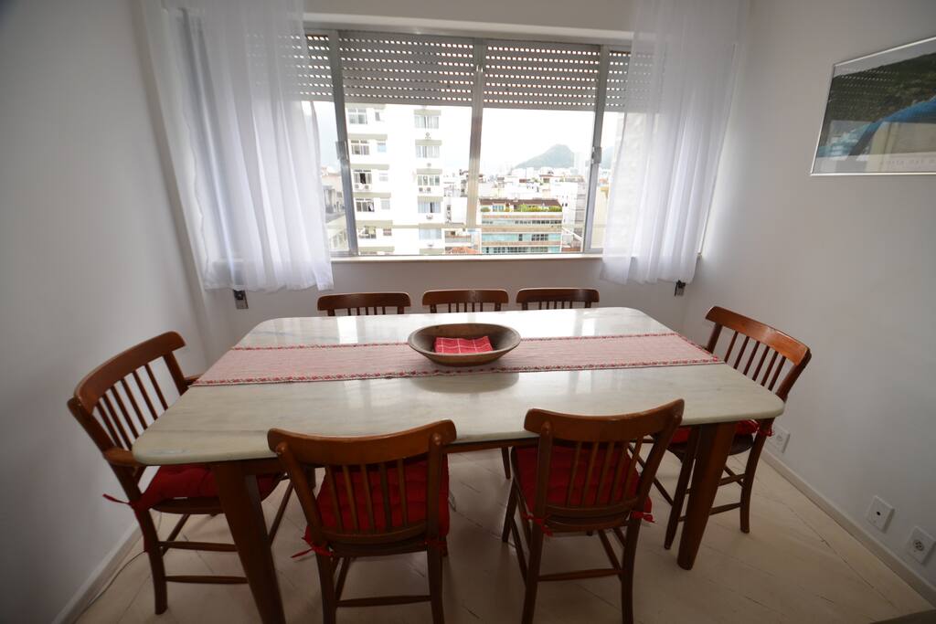 SALA DE ESTAR - Mesa de mármore com 07 cadeiras, Sofá de 03 lugares, abajur, ventilador de teto, TV LCD e mesinhas de telefone e som portátil.