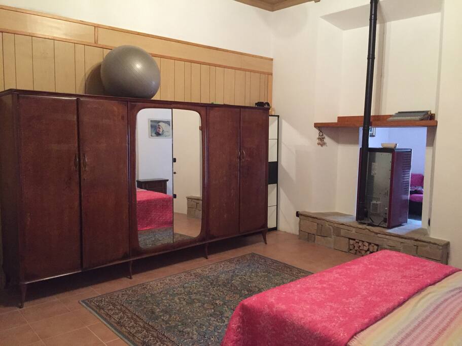 Bedroom with a queen bed, a single bed, wardrobe and desk.