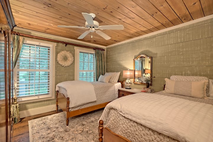 ห้องนอนผู้เข้าพักชั้นล่างในบ้านหลักมีเตียงแฝด 2 เตียงตู้เสื้อผ้าและวิวภูเขาที่สวยงาม