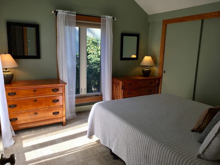 Dormitorio principal con cama tamaño queen y techos abovedados.