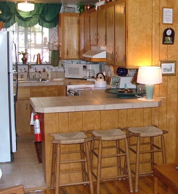 Convenient and well equipped knotty pine kitchen with breakfast bar.