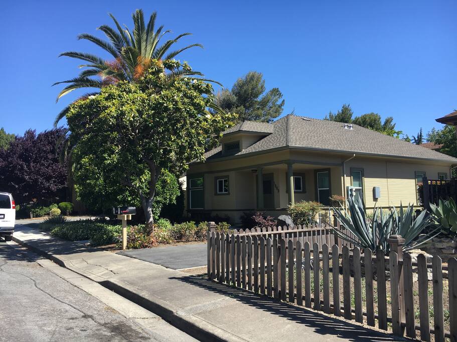 Quiet residential street with driveway access, front porch, and meticulously-manicured grounds