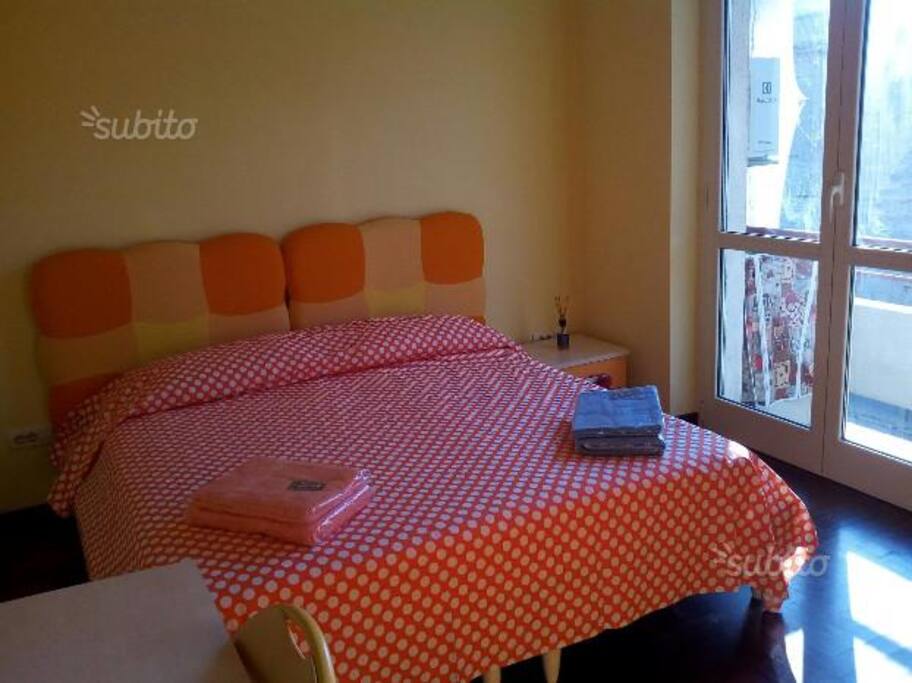 Camera da letto matrimoniale con lenzuola e asciugamani