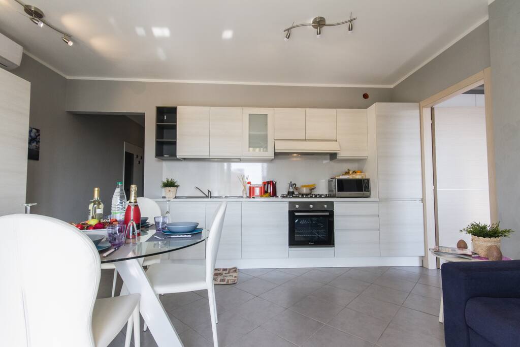 Living area with full kitchen, dining table, sleeping sofa and HD TV