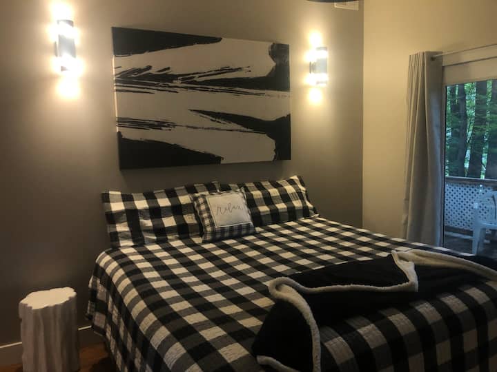 Main bedroom with king bed and private balcony overlooking wooded area and a view of Budd Lake.