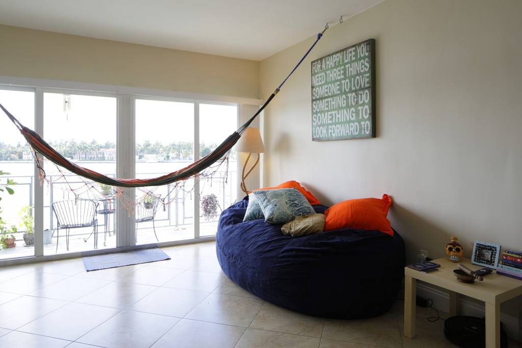 Living room has cozy 2 person bean bag sofa and hooks for two hammocks to watch movies from.