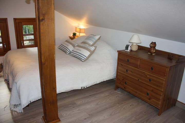 Chambre 1. Au premier étage, une chambre "nid douillet" avec un grand lit double (160 cms) une télé et un lecteur DVD / On the first floor, a cozy room with a queen size bed, TV and DVD player 