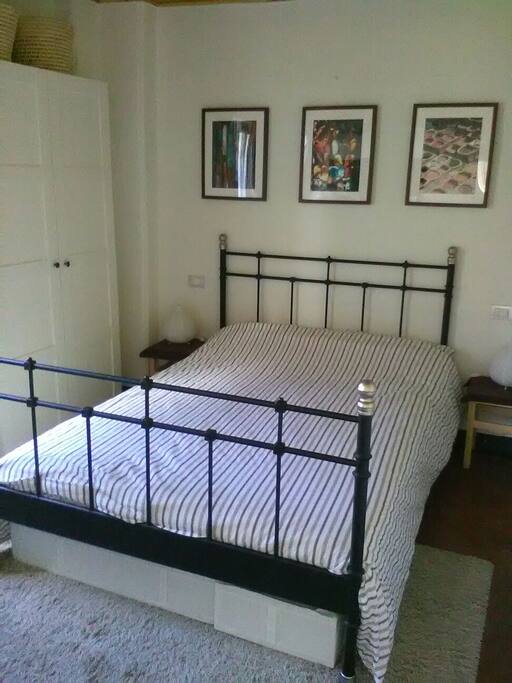 The bedroom with a double bed, wardrobe and a chest of drawers.