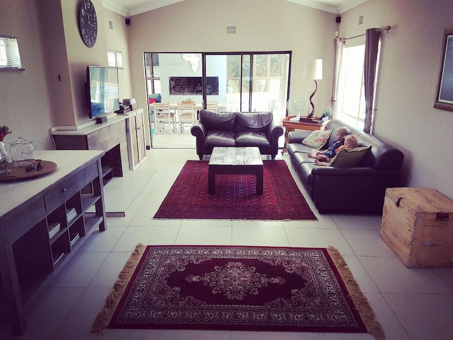 Sunny and spacious living area, leading to braairoom and outside patios.