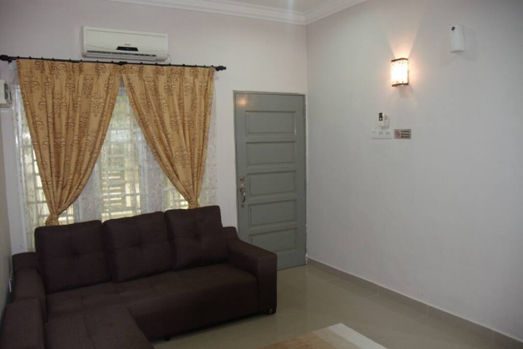 This is the living room. It is furnished with 3 seater sofa , air conditioner, and a foot massage.