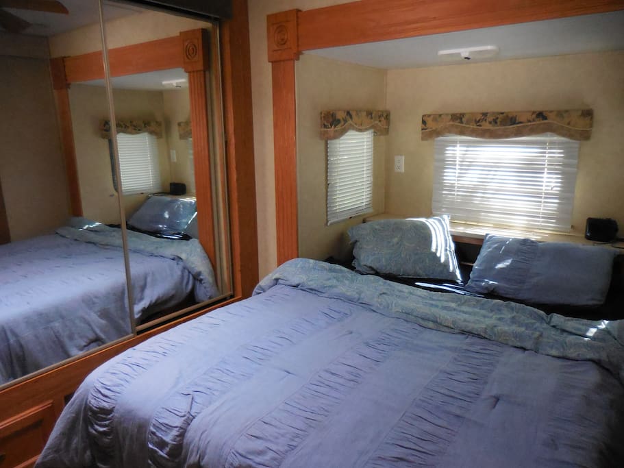 Bedroom with closets, built in drawers, doors and a queen size bed