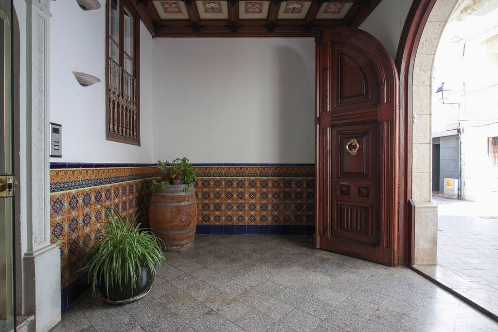 entrada principal del edificio "Ca l'Escarrà", donde se puede apreciar el techo pintado y trabajado en relieve