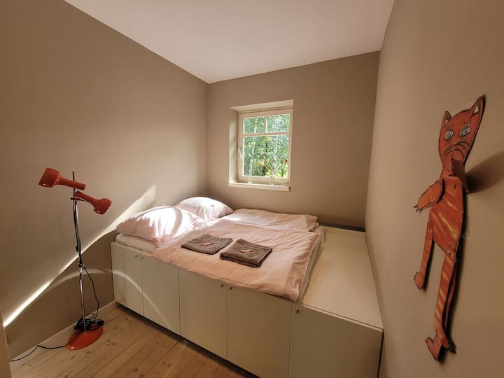 Schlafzimmer 1 zum Bach mit Podestbett. Es liegt direkt gegenüber vom Bad.