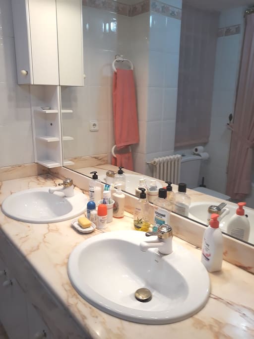 cuarto de baño con bañera y dos lavabos , al lado de la habitacion