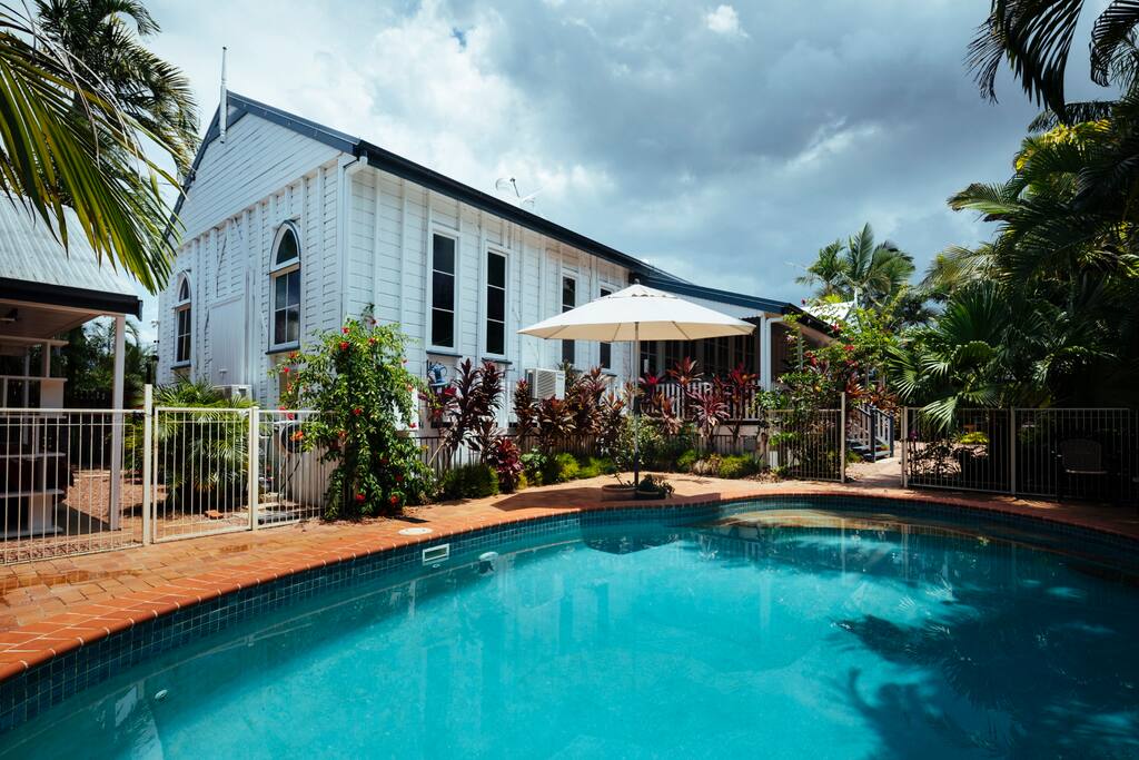 Converted Church with large pool in a tropical garden setting.