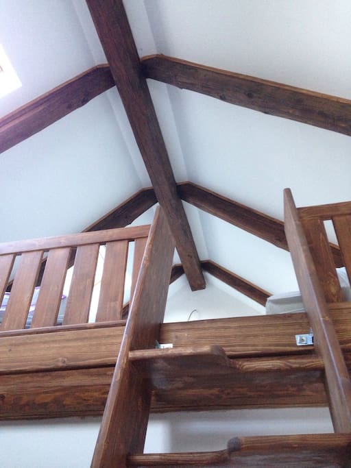 There are ladder-like stairs leading up to a sleeping loft, where there are two beds 90x200.