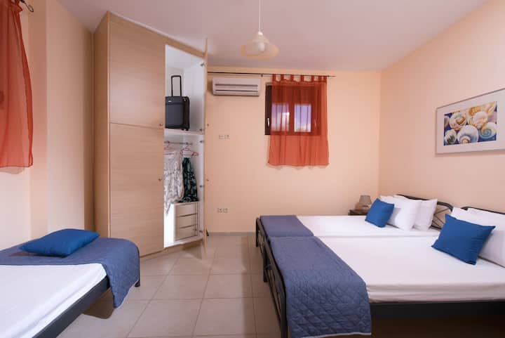 One of the 2 bedrooms with 3 single beds