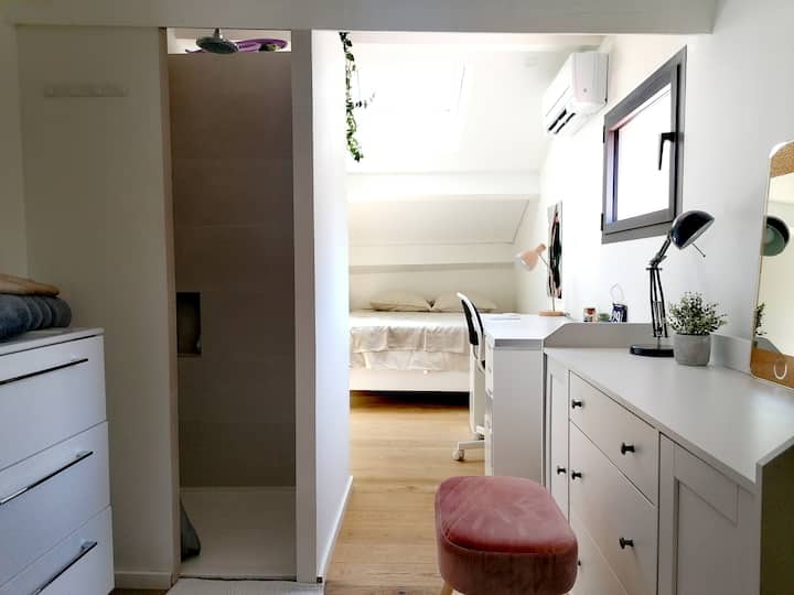 DORMITORIO # 3 ARRIBA - CAMA DOBLE bajo los tejados con una ventana y un velux,  un baño privado (ducha y lavabo), un área de escritorio y aire acondicionado.