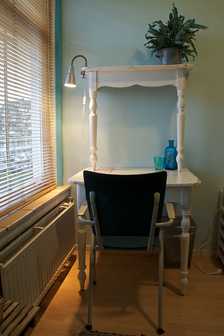 The room has a small desk/ dining table.