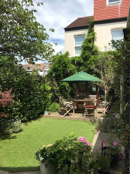 Small but pretty and extremely private back garden with artificial grass, (so it's perfect all year round!) we have wooden folding doors off the sitting room and kitchen, which is great in summer.