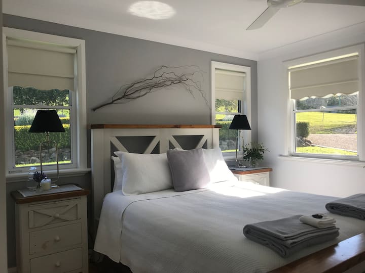 Main bedroom is decorated in white and tones of greys.It has a comfortable queen bed and overlooks the extensive Lavender and Rose Gardens.The room faces north and has easy access to the bathroom.  A Port-a cot can be set up in this room with linen. 