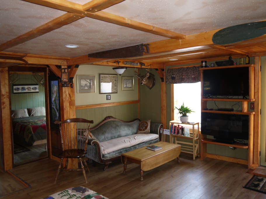 living area with TV on top and fireplace on bottom, entrance to bedroom 2 on left