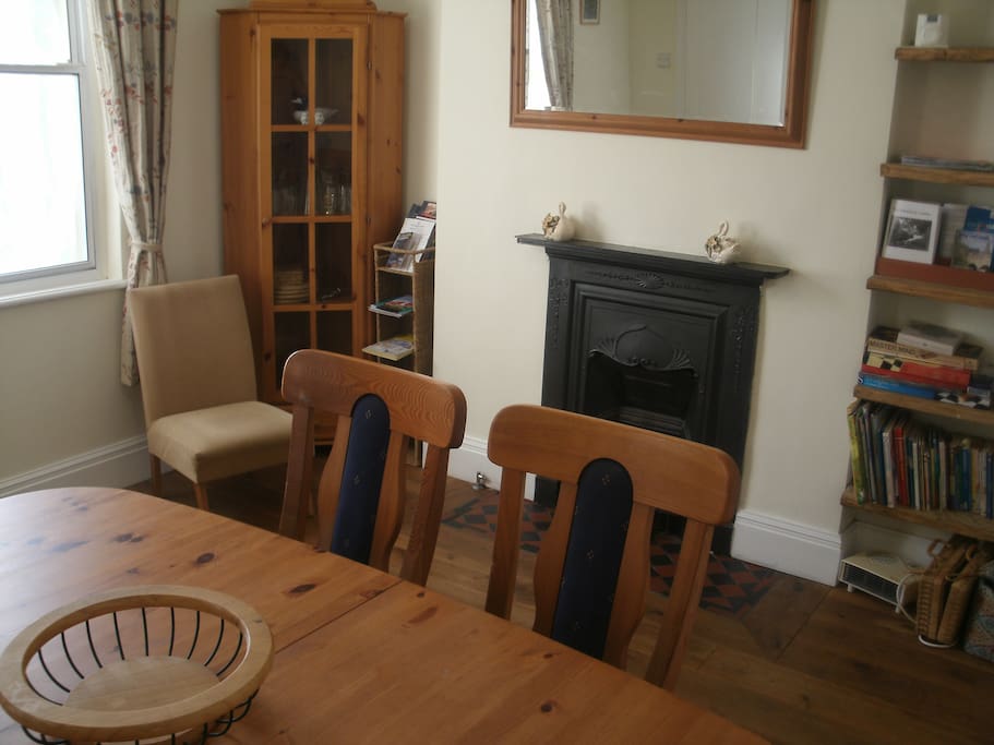 Dining room showing glasses cabinet, toys, books and dining table which seats 6 or more.