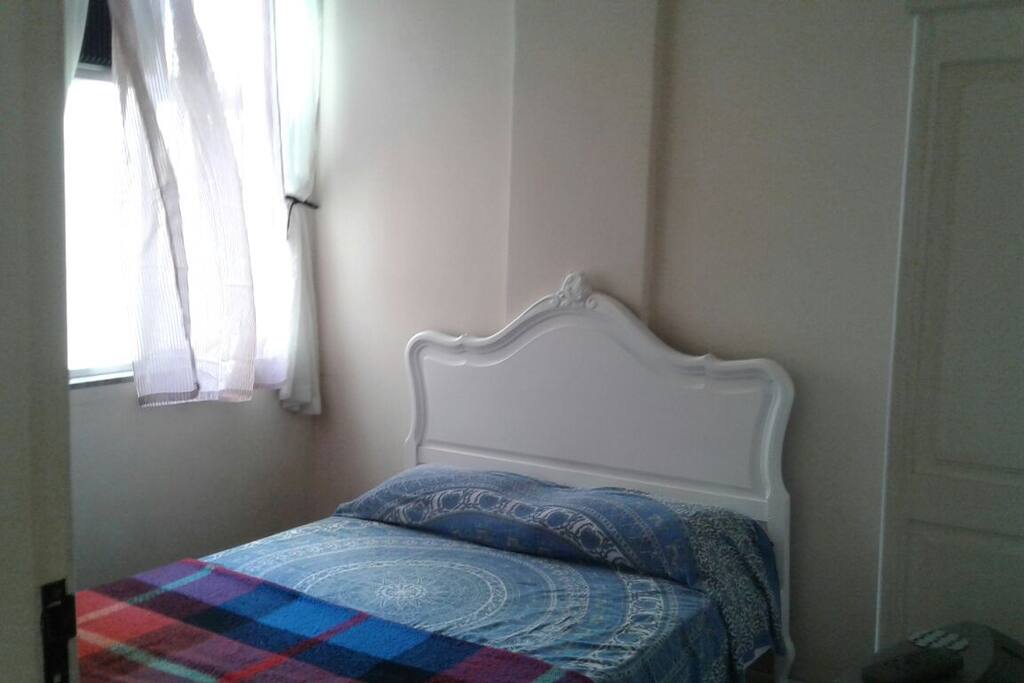 Quarto com cama de casal, armário de duas portas e ar condicionado.