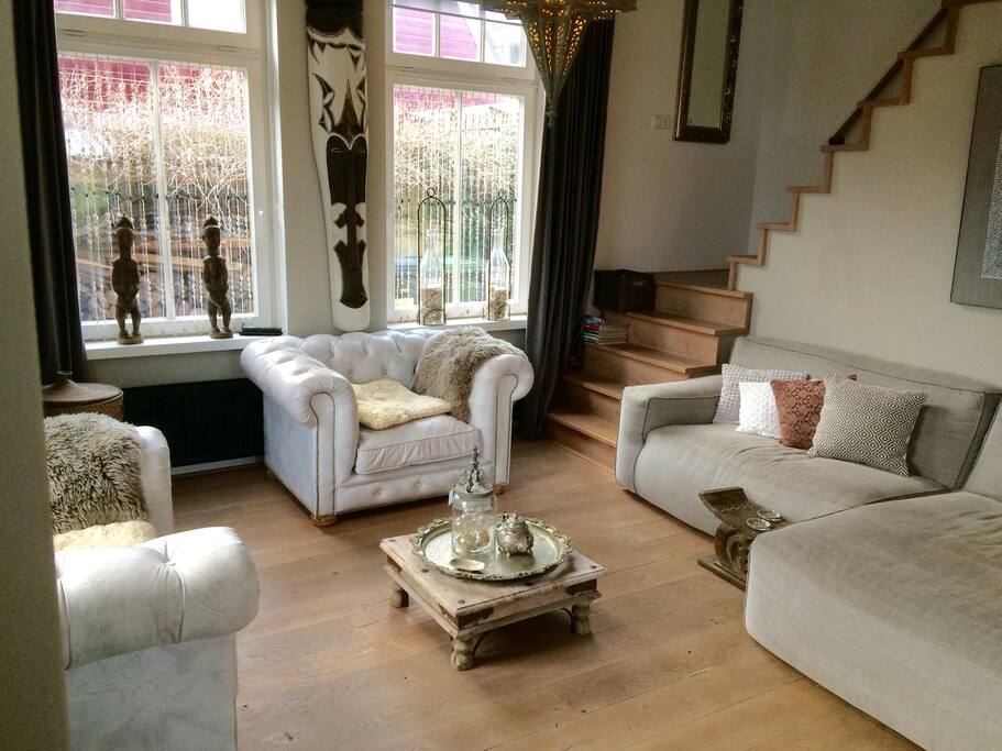 Woonkamer met lounge bank en wit leren Chesterfields