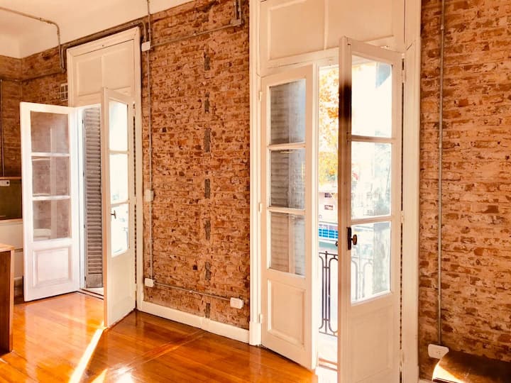 غرفة معيشة بنوافذ كبيرة ومشرقة تطل على الأمام. شرفة فرنسية.