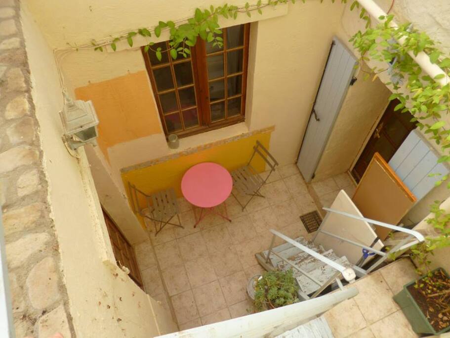 Petit patio avec à la gauche la porte d'entrée vers la petite chambre