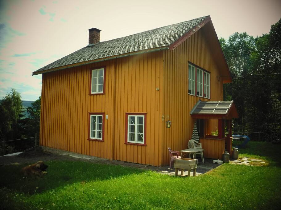 liten sittegruppe ved inngang og stor sittegruppe på langside med grill