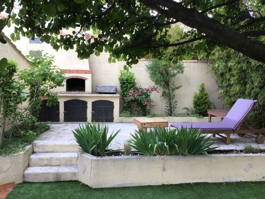 La terrasse avec le coin barbecue et plancha