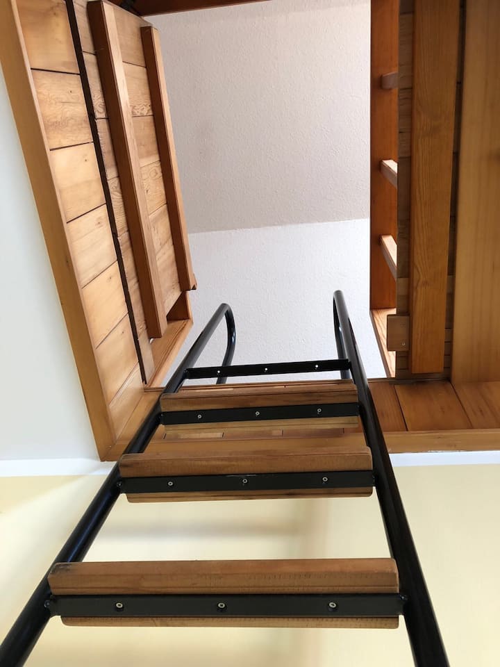 บันไดสูงชันชั้นบนไปยังห้องในห้องใต้หลังคา