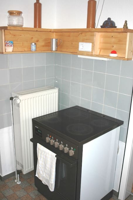 In der Küche finden Sie eine Herd mit vier Kochplatten und einem Umluft-Backofen, außerdem einen Küchenblock mit Doppel-Waschbecken. Im Nebenraum befindet sich ein Kühlschrank (mit Gefriereinheit) sowie Regale für Ihre Vorräte.