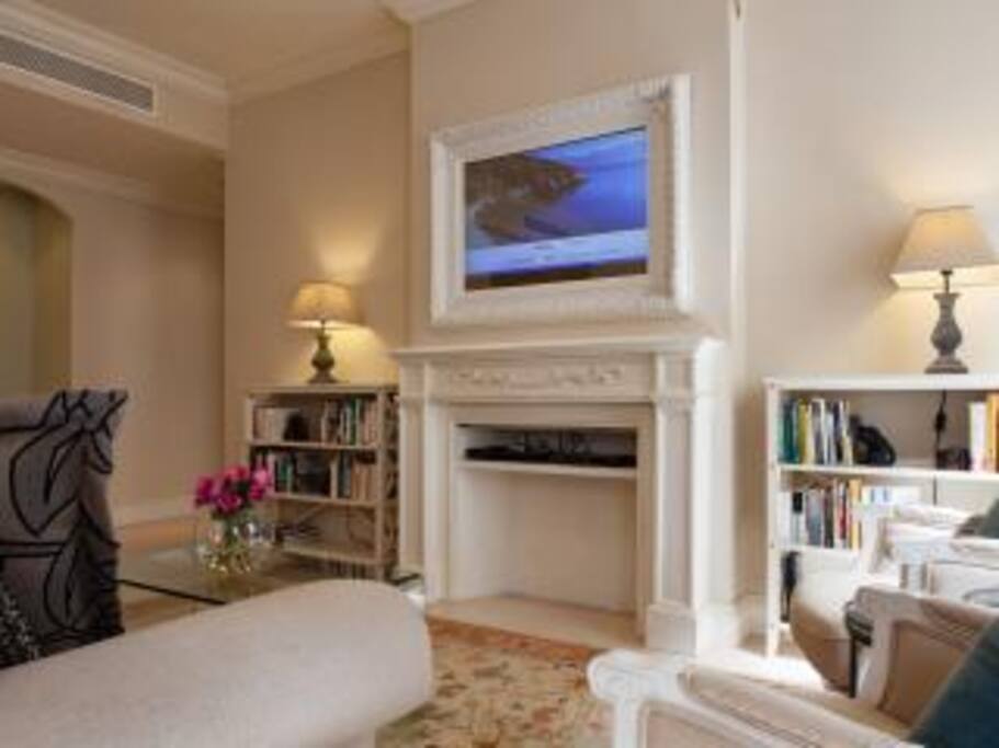 LIVING AREA/DINING AREA
The original stone walls of the living and dining areas as well as the decoration with historic bas-reliefs from a Spanish church make the heart of this apartment special and warm.
The living room is spacious and relaxing. It is comfortable for reading, catching up on email, or watching the wide screen TV. If you prefer a quiet chat with friends and family, the television won't intrude at all as it is concealed by an elegantly framed mirror above the fireplace when not illuminated (see photo). Wool carpets make the rooms extra cozy.
The dining area easily accommodates six or even eight!
