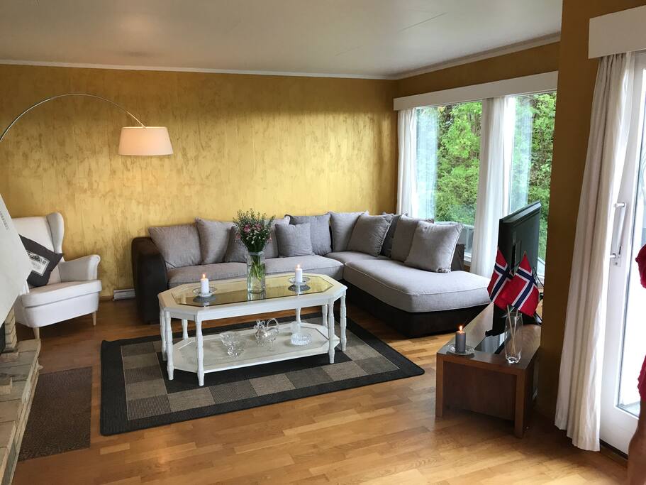Living room with large sofa, table, chair, TV bench and large 55 inch TV.