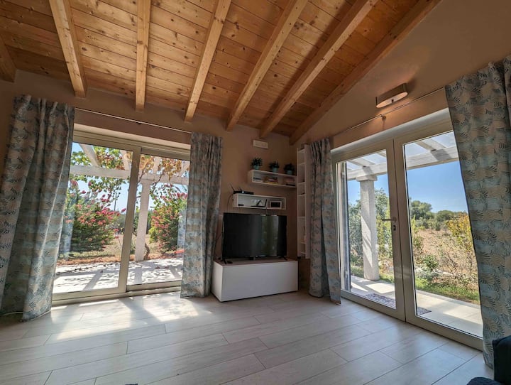 منطقة معيشة مشرقة ومريحة تحيط بها الطبيعة. تلفزيون إل جي سمارت 49 بوصة.