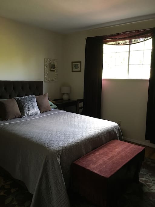 Comfortable queen bed, with lots of natural light and a garden view.
